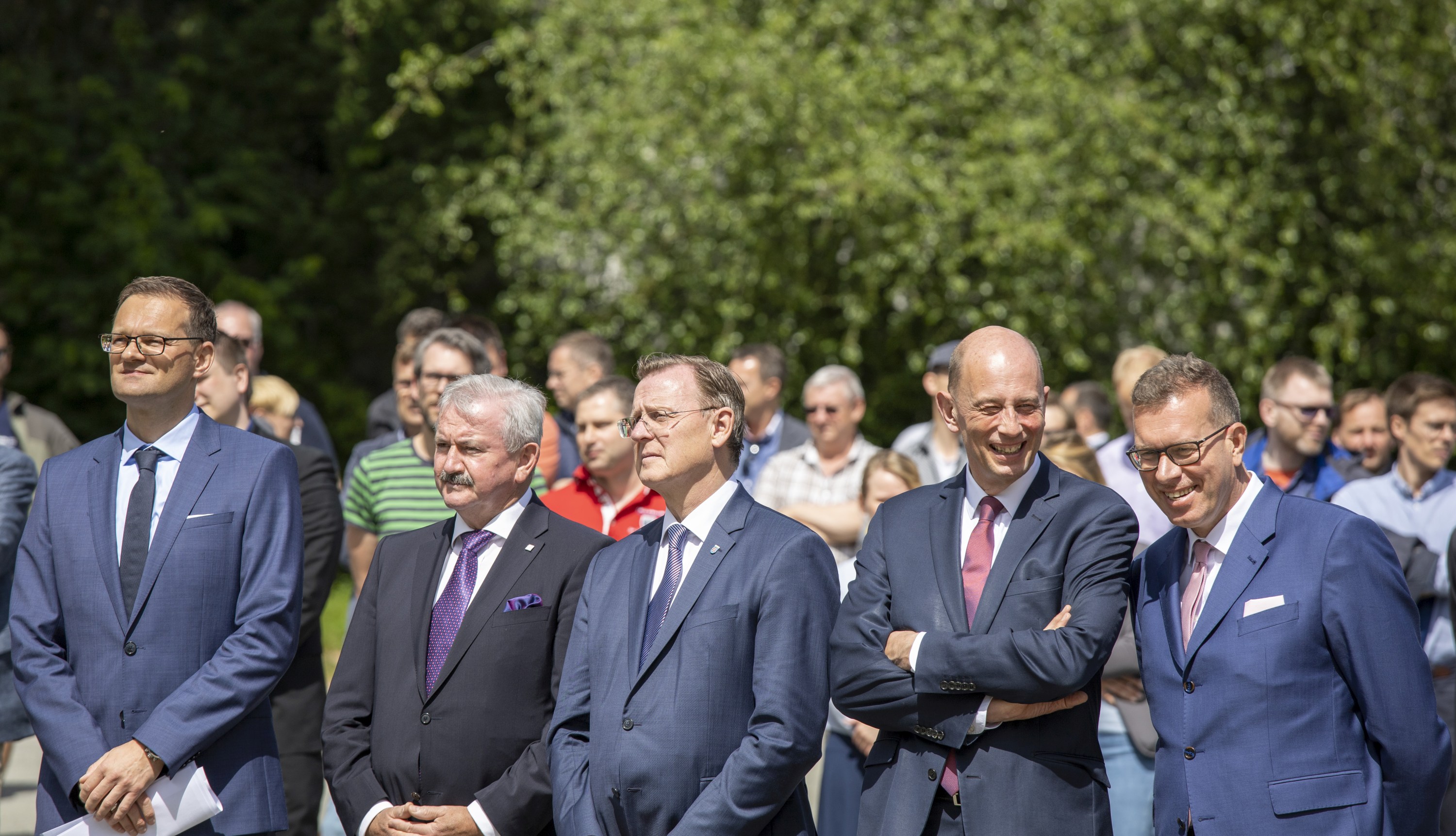 Gruppe von Männern im Anzug steht beieinander, sie warten